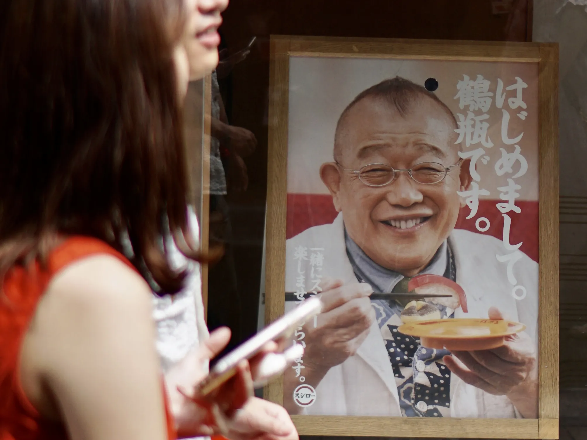 A picture of a smiling man promoting sushi in an advert in Tokio.